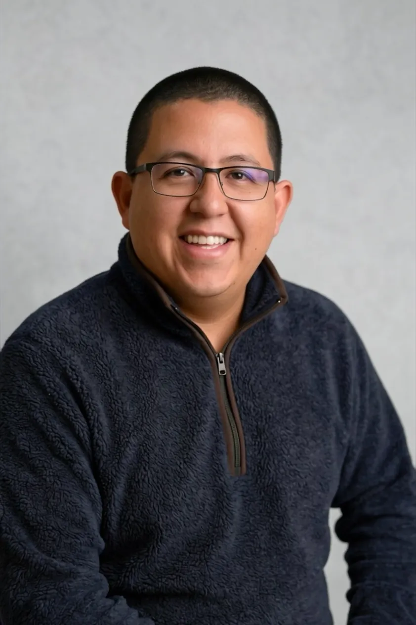Cristian Penarrieta smiling, in a navy fleece pullover